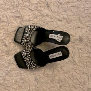 These Steve Madden open toe heels are black with silver spikes